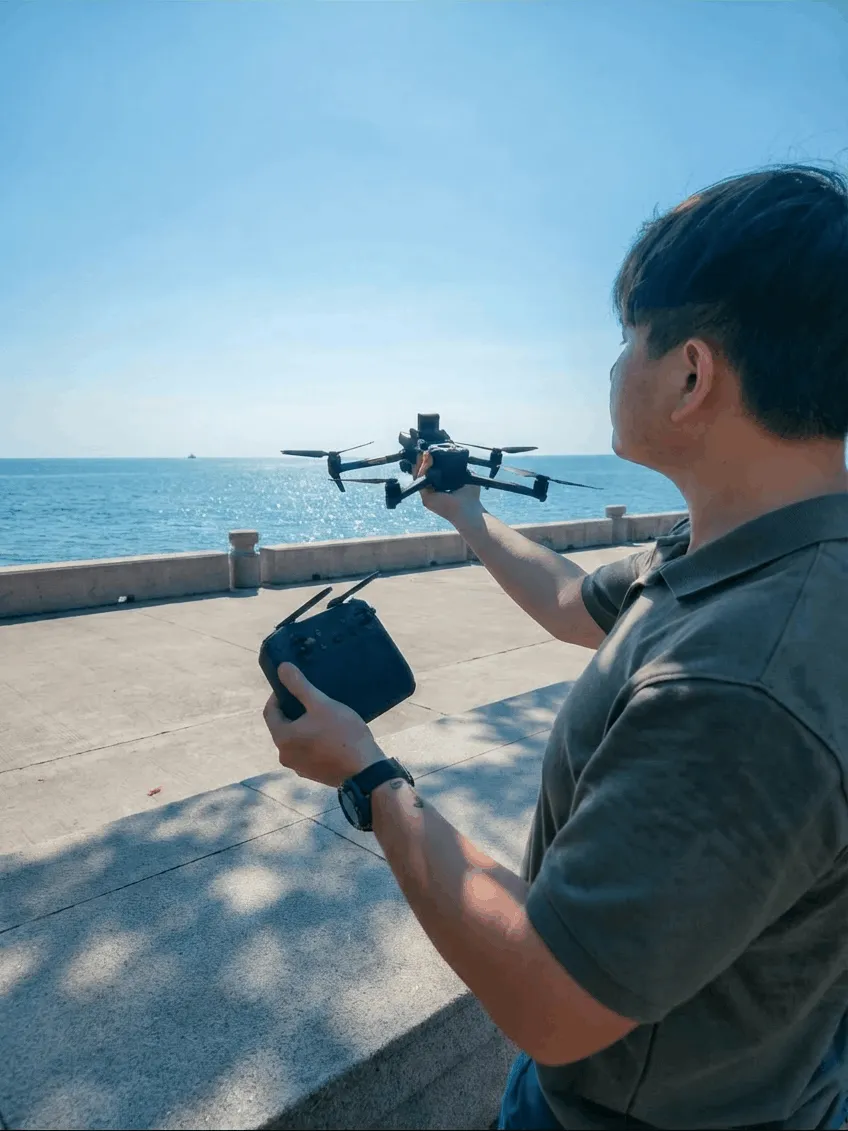 APS Drone Pilot launching our drone next to the beach